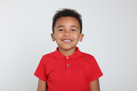 Portrait of cute African-American boy on light grey backgroundの写真素材