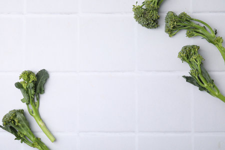 Fresh raw broccolini on white tiled table, flat lay and space for text. Healthy foodの写真素材