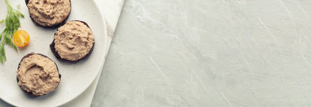Slices of bread with delicious pate served on white marble table, top view. Banner design with space...