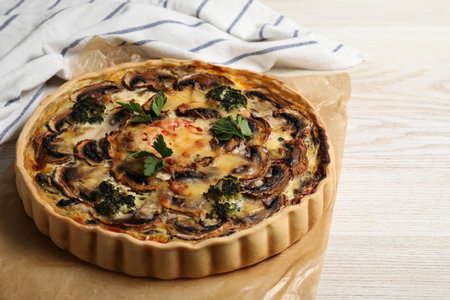 Delicious quiche with mushrooms and parsley on white wooden table, closeupの写真素材