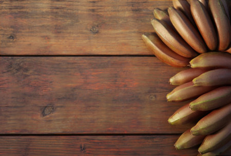 Tasty purple bananas on wooden table, top view. Space for textの写真素材