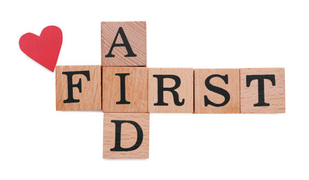 Words First Aid made of wooden cubes and cardboard heart isolated on white, top viewの写真素材