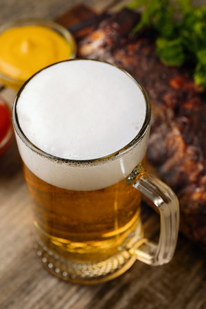 Mug with tasty beer on wooden tableの写真素材