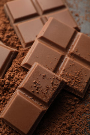 Delicious milk chocolate and cocoa powder on gray table, closeupの写真素材