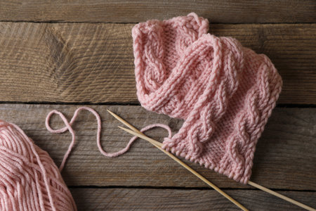Soft pink woolen yarn, knitting and needles on wooden table, flat layの写真素材