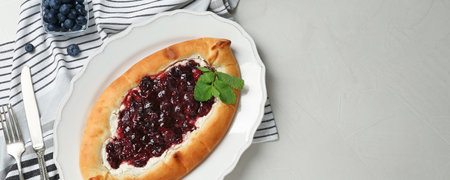 Delicious sweet cottage cheese pastry with jam served on light table, flat lay. Banner design with...