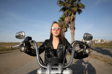 Beautiful woman riding motorcycle on sunny dayの写真素材