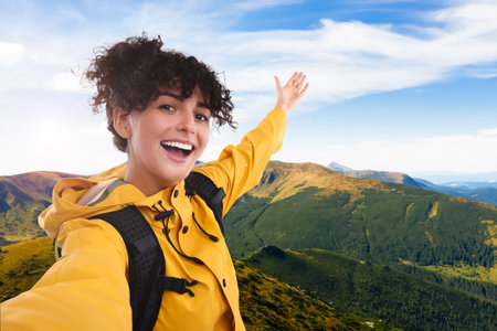 Beautiful young woman taking selfie in mountainsの写真素材