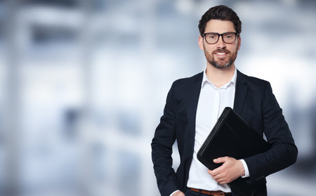Handsome real estate agent with leather portfolio in office, space for text