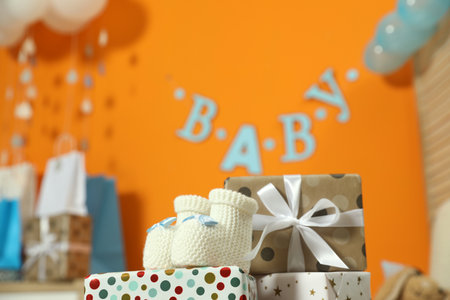 Baby shower party. Festive decor, gift boxes and boots in stylish room, space for textの写真素材