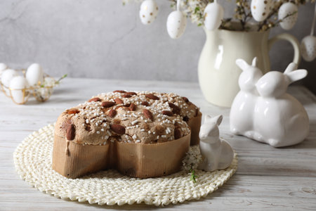 Delicious Italian Easter dove cake (Colomba di Pasqua) and festive decor on white wooden table