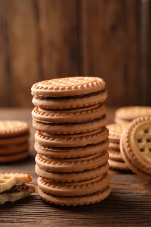 Tasty sandwich cookies with cream on wooden table, closeup