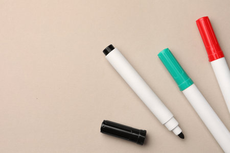 Bright color markers on beige background, flat lay. Space for textの写真素材