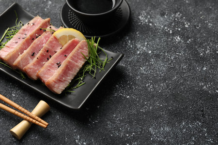 Pieces of delicious tuna steak served on black table. Space for textの写真素材