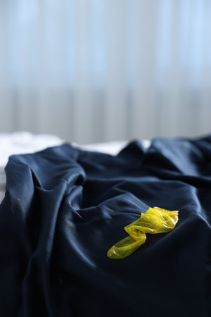 Unrolled condom on bed in bedroom. Safe sexの写真素材
