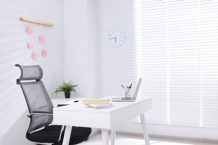 Desk and comfortable chair in modern office, space for text. Interior designの写真素材