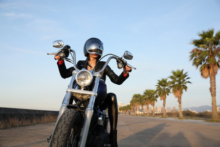 Woman in helmet riding motorcycle on sunny dayの写真素材