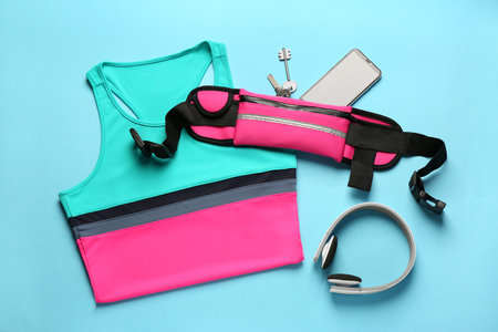 Flat lay composition with stylish pink waist bag on light blue backgroundの写真素材