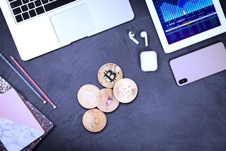 Bitcoins, stationery and different gadgets on gray table, flat layの写真素材