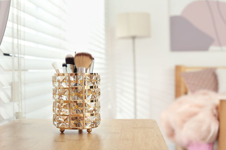 Set of professional makeup brushes on wooden table in teenager's room. Space for textの写真素材