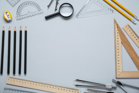 Flat lay composition with different rulers and compasses on light gray background. Space for text
