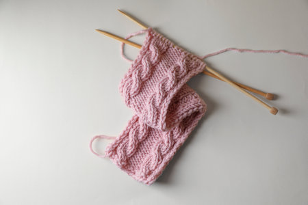Pink knitting and needles on beige background, top viewの写真素材