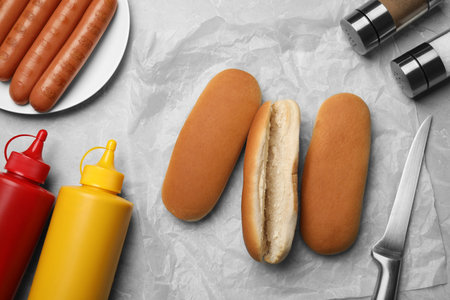 Different tasty ingredients for hot dog on light gray marble table, flat layの写真素材