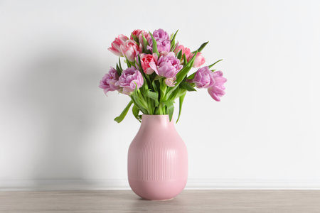 Beautiful bouquet of colorful tulip flowers on floor near white wallの写真素材