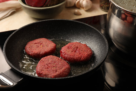 Cooking vegan cutlets in frying pan on stove, closeupの写真素材