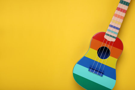 Colorful ukulele on yellow background, top view with space for text. String musical instrumentの写真素材