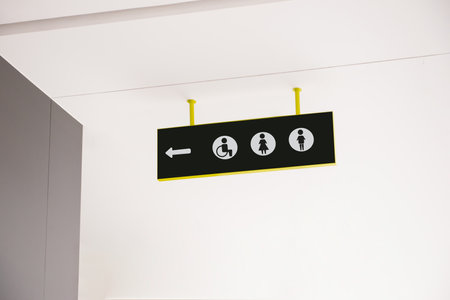 Public toilet sign with symbols and arrow showing directionの写真素材