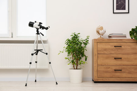 Tripod with modern telescope in stylish roomの写真素材