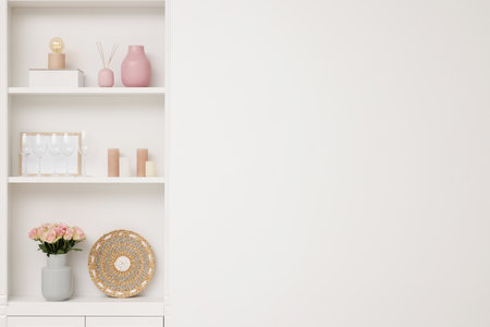 Shelves with different decor near white wall, space for text. Interior designの写真素材