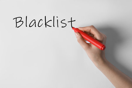 Woman writing word Blacklist on whiteboard, closeupの写真素材