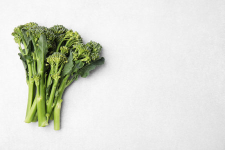 Fresh raw broccolini on white background, flat lay and space for text. Healthy foodの写真素材