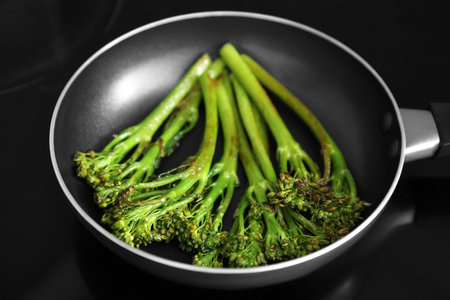 Frying pan with tasty cooked broccolini on cooktop, closeupの写真素材