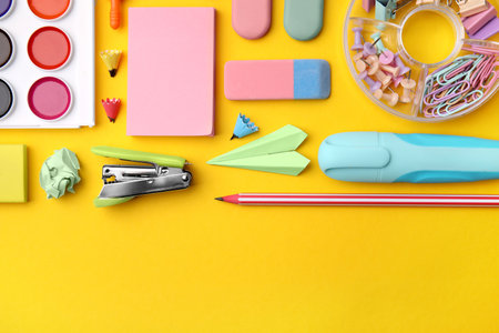 Flat lay composition with different school stationery on yellow background, space for text. back to schoolの写真素材