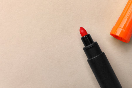 Bright orange marker on beige background, flat lay. Space for textの写真素材