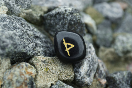 Black rune Wunjo on stones outdoors, closeupの写真素材