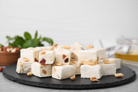 Pieces of delicious nutty nougat on black boardの写真素材