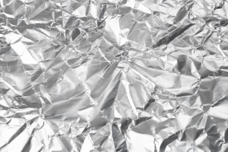 Crumpled silver foil as background, closeup viewの写真素材