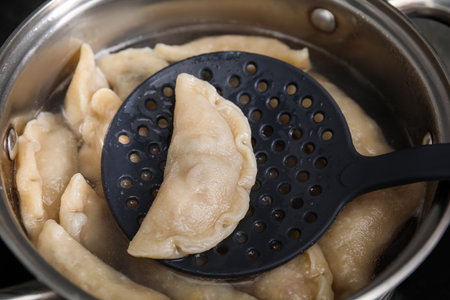 Boiling delicious dumplings (varenyky) on skimmer over pot, closeupの写真素材