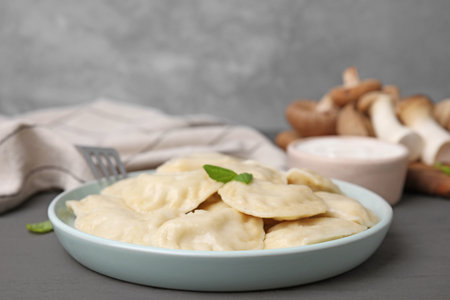 Plate of delicious dumplings (varenyky) on gray wooden table, closeupの写真素材