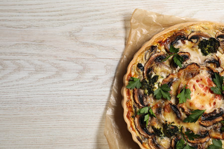 Delicious quiche with mushrooms and parsley on white wooden table, top view. Space for textの写真素材