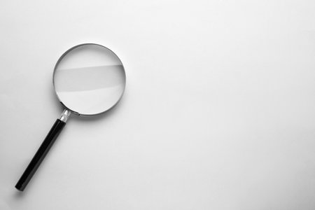 Magnifying glass on light gray background, top view. Space for textの写真素材