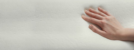 Woman touching memory foam pillow, closeup. Banner design with space for textの写真素材