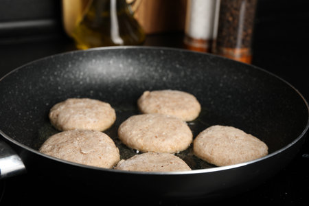 Cooking vegan nuggets in frying pan on cooktop, closeupの写真素材