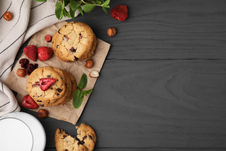 Cookies with freeze dried fruits, mint and nuts on gray table, flat lay. Space for text