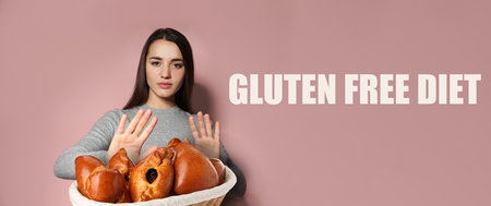 Gluten free diet. Woman refusing from wicker basket with pastries on dusty pink background, banner designの写真素材