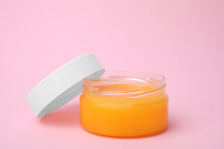 Open jar with petrolatum on pink background